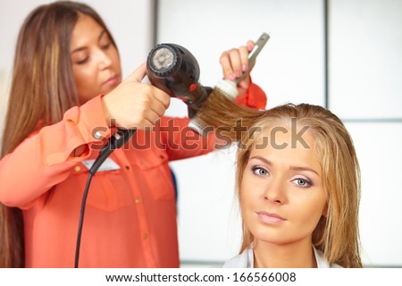 Hair salon. Women`s haircut. Use of hair dryer.
