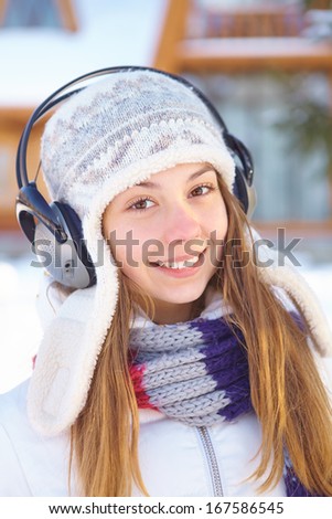 Outdoors on a winter day. Woman listening music.