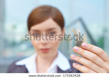 Businesswoman holds door key.