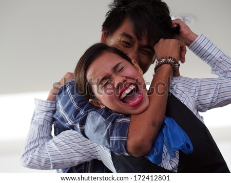 A lady being strangled by a man from behind