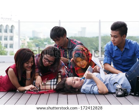A group of college students studying outside campus building