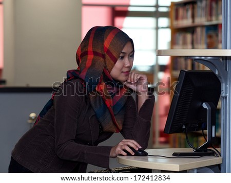 A girl using computer terminal in a library