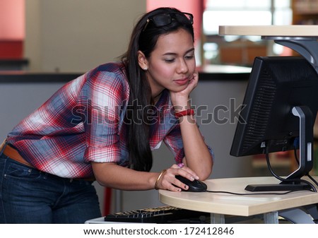 A girl using computer terminal in a library