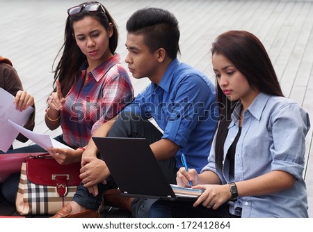 A group of college students studying outside campus building