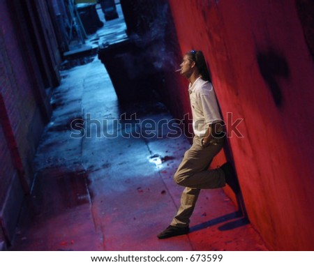 man smoking in back alley