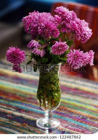 Autumn flowers in the vase on the table