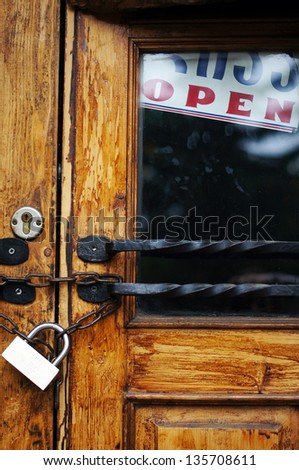 Old door with padlock and open sign