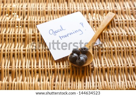 Fresh picked organic blueberries in a white plate on a woven basket slate background