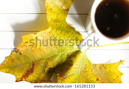 Autumn time: cup of tea, maple yellow leave and Good morning note