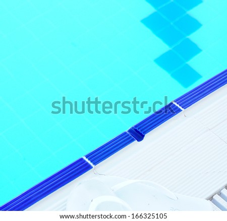 Outdoor pool in the tropical area with blue water and ladder