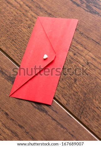 Red envelope with note, hearts and rose petals