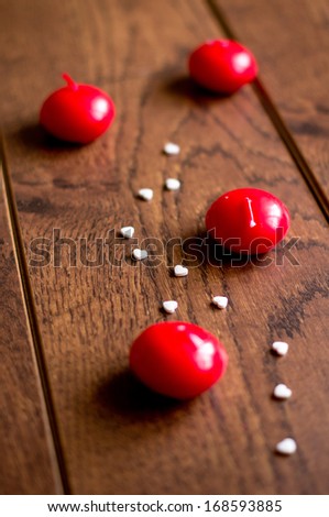 Red candles and white hearts on the wooden desk