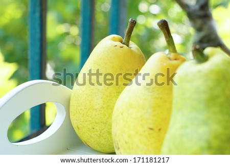 Natural pear juice in a glass bottle and fresh pears on the table
