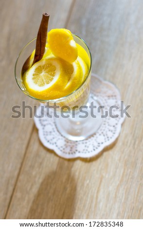 Glass with cut lemon fruit and water