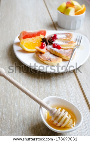 Healthy food, pancakes with fresh fruits, honey and sour cream, green tea