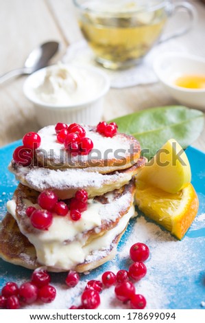 Healthy food, pancakes with fresh fruits, honey and sour cream, green tea