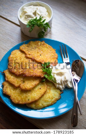 Traditional ukrainian dish - fried potato pancakes or deruny on the plate with sour cream