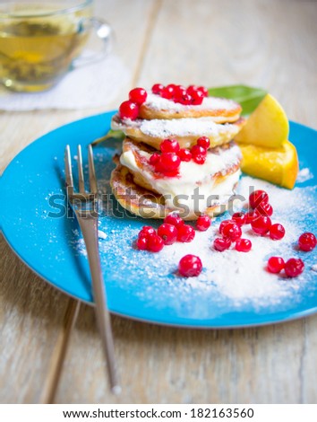 Healthy food, pakcakes with fresh fruits, honey and sour cream, green tea