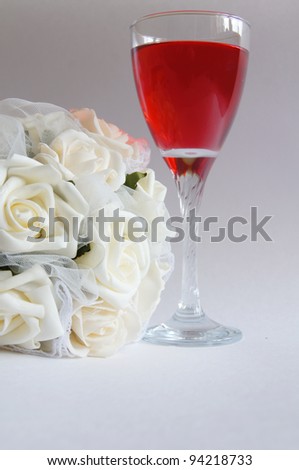 Glass of rose wine and white roses bouquet for bride