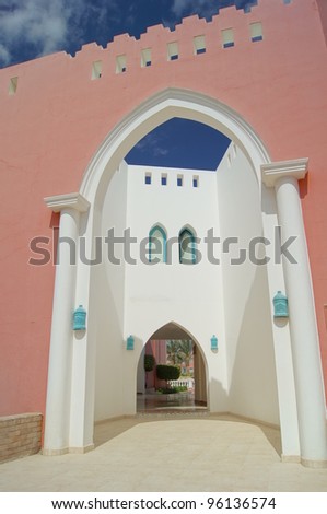 Courtyard of mediterranean villa with ceramic tile walkway and blooming bushes in Egypt