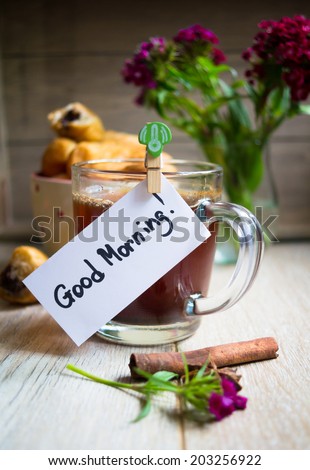 Croisant with chocolate, flowers and coffee with good morning note