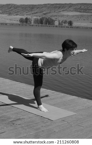 a pretty woman doing yoga at the lake