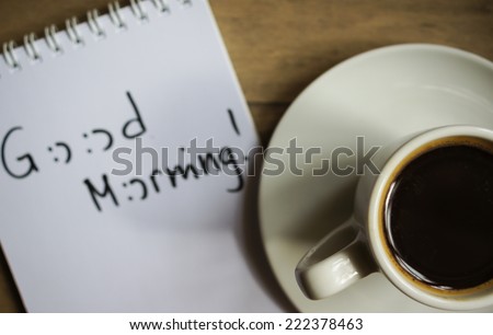 Cup of black coffee and good morning note on the table
