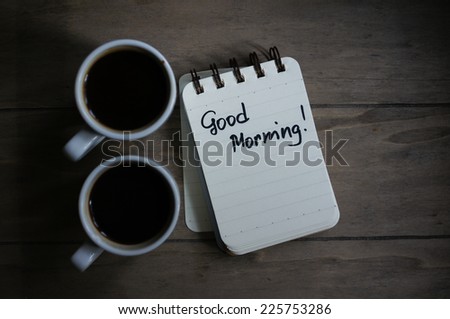 Cup of black coffee and good morning note on the table