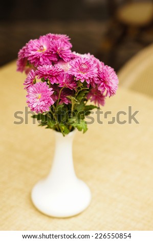 Autumn flowers in the vase on the table