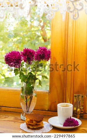 Autumn time, flowers in the vase and cup of coffee on the table with note