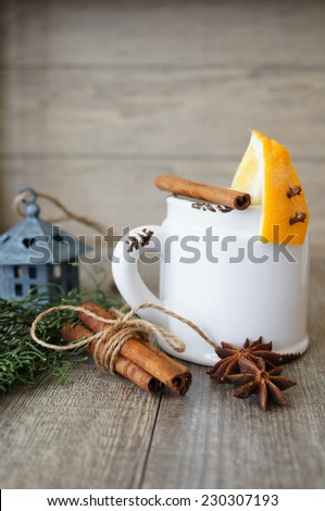 Mug of tea and orange on the table with christmas time decoration