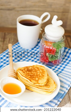 Pancakes with honey and jam with cup of tea for healthy breakfast