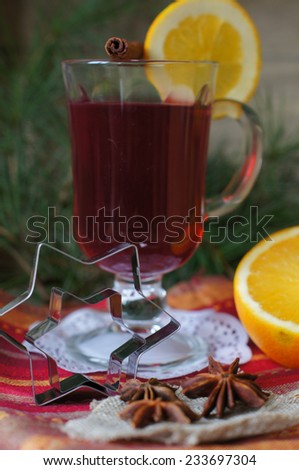 Glass of mulled wine with orange and christmas decor