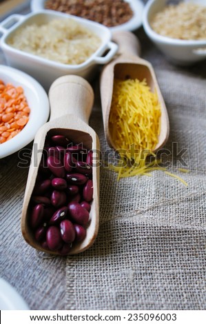 various food ingredients : beans, legumes, peas, lentils in wooden spoon and glass bowls