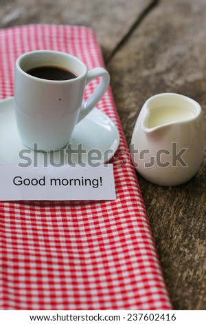 Cup of black coffee with milk and Good morning note