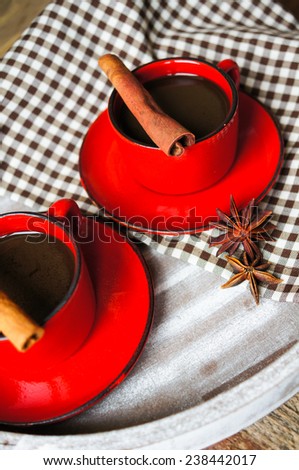 Red cup of coffee with coffee beans and spices cinnamon and anise star