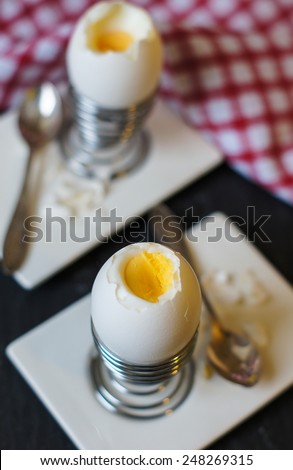 Soft boiled egg in egg cup and served with lettuce leaves
