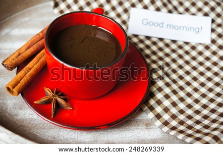Red cup of coffee with coffee beans and spices cinnamon and anise star