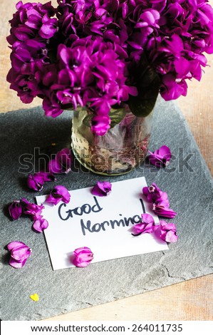 First spring flowers on the table with good morning note