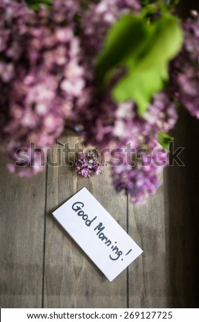 Lilac flowers and good morning note on the rustic style background