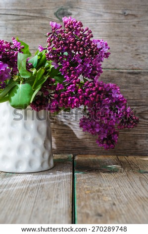 Lilac flowers in a pot in rustic interior