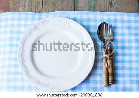 Table Setting with napkin and silverware on wooden table