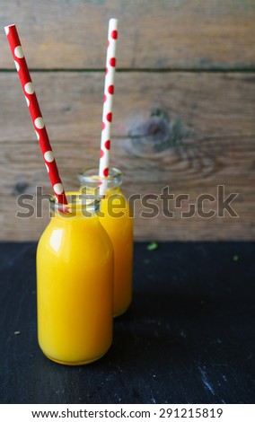Vintage style bottles with orange juice and straws