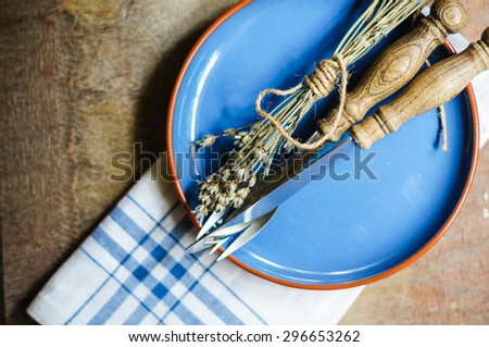 Rustic Table Setting with napkin, silverware and dry lavendre lowers on old wooden table