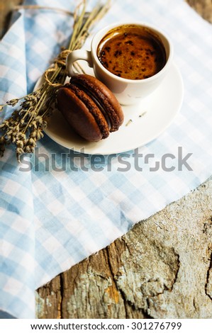 cup of black coffee with chocolate macaroon and lavender flowers