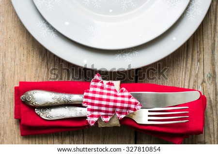 Rustic christmas table setting with bright plates and silverware