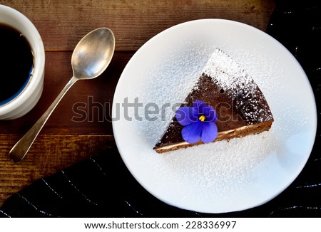Homemade chocolate cake with cream cheese, walnuts and flowers, sprinkled with sugar powder