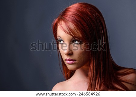 Landscape orientation portrait of red haired woman with bare shoulders