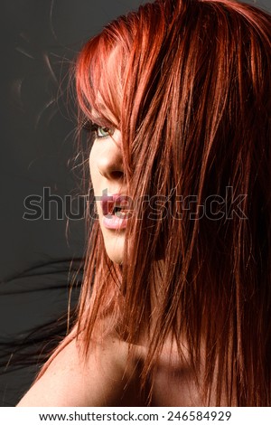 Portrait of red haired woman with hair obscuring face