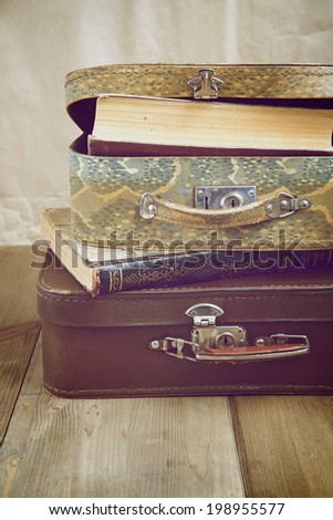 Shabby suitcases with old books, vintage toning